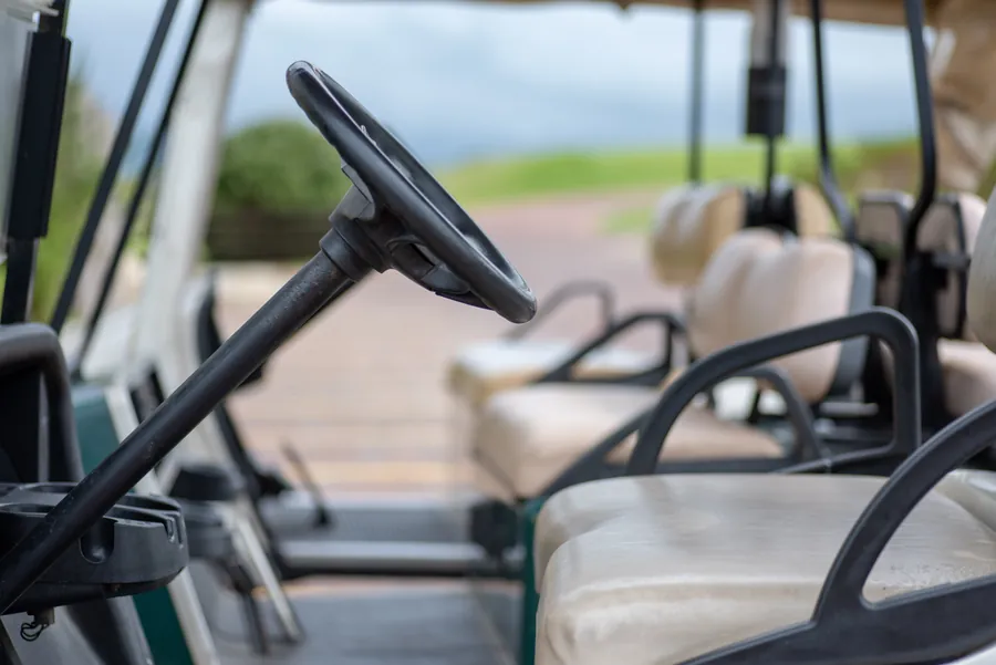 Steering wheel and seats in an empty golf cart