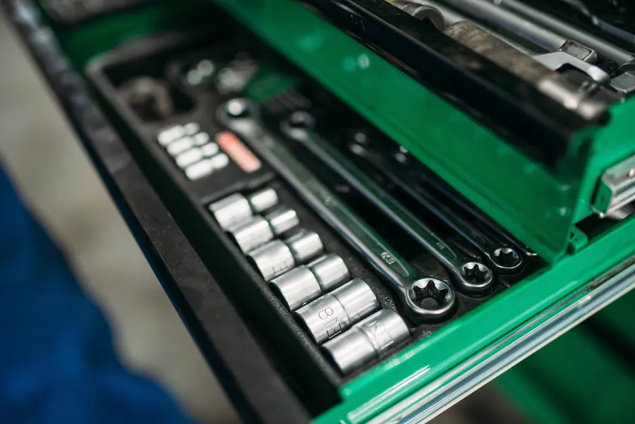 Organized tools in a green toolbox drawer