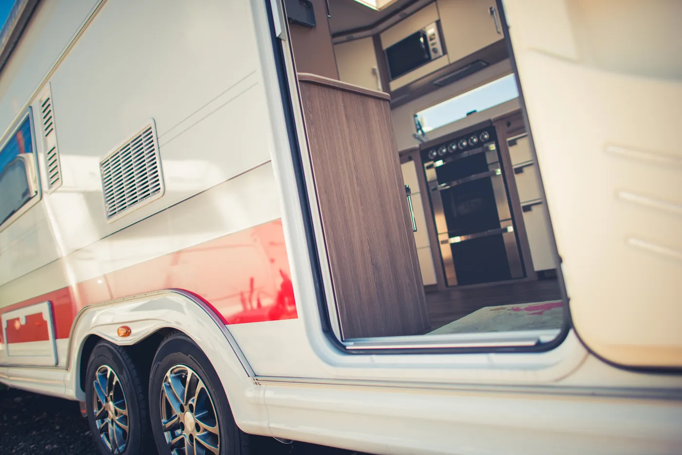 Travel trailer exterior with wheels and an open doorway