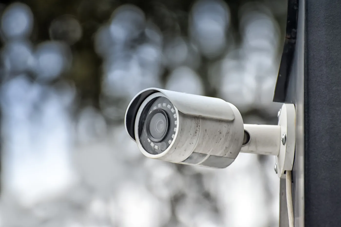 Outdoor security camera against softly blurred trees