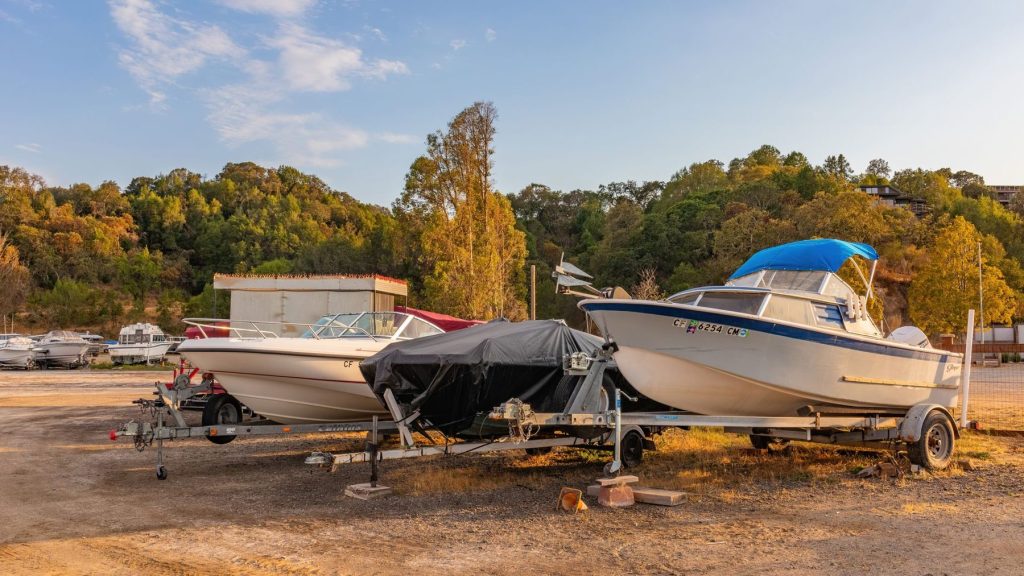 Boats on trailers under covers in a storage lot